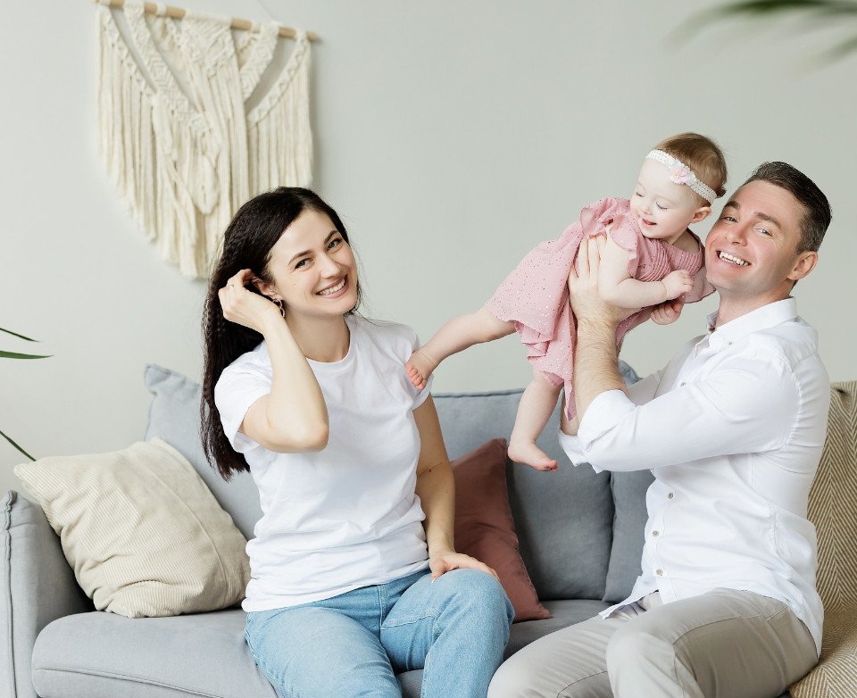 happy parents with toddler in air conditioned room